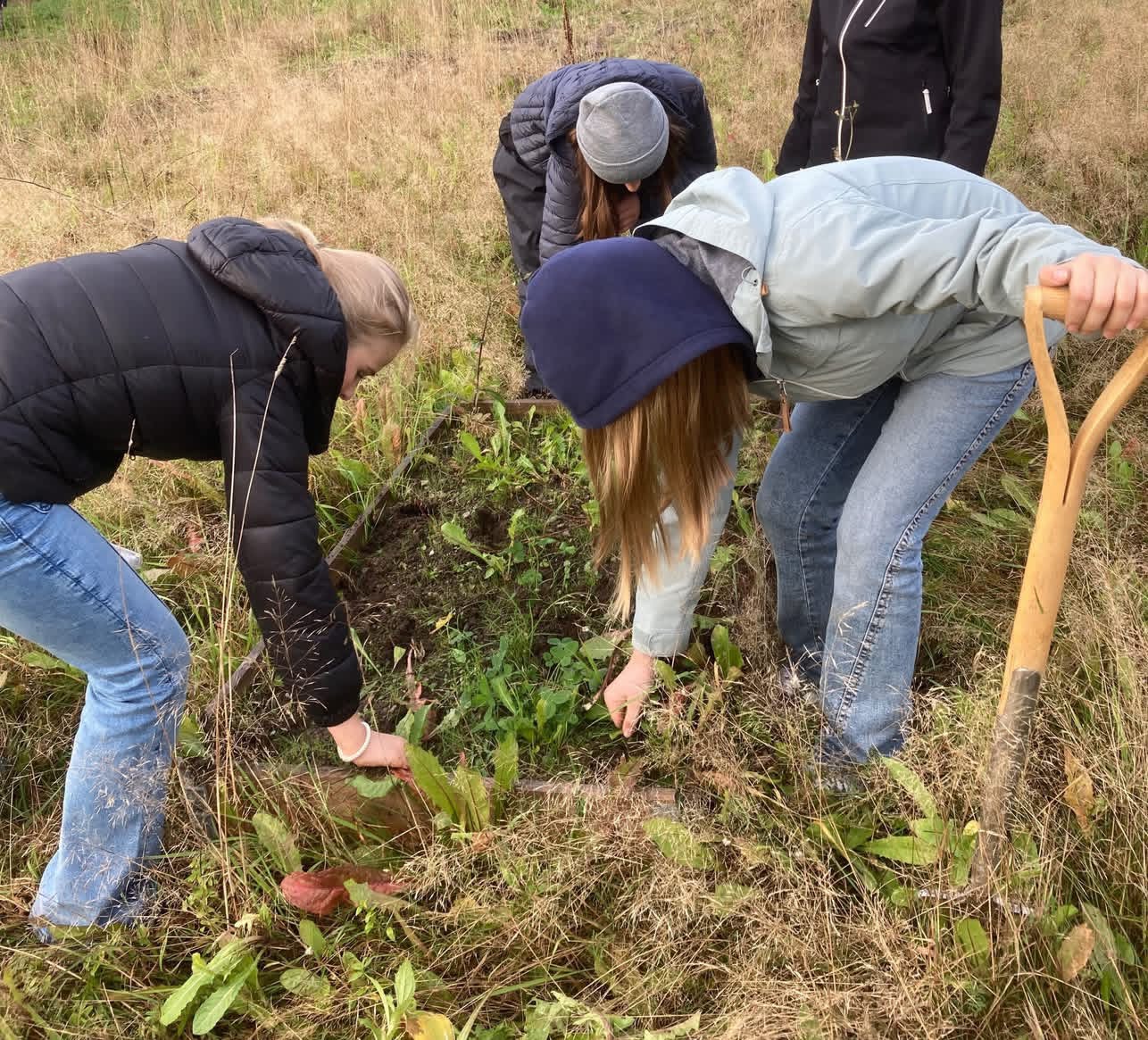 Elever med spaden i jorda utenfor skolen